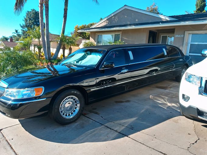 A black limo parked in front of a house.